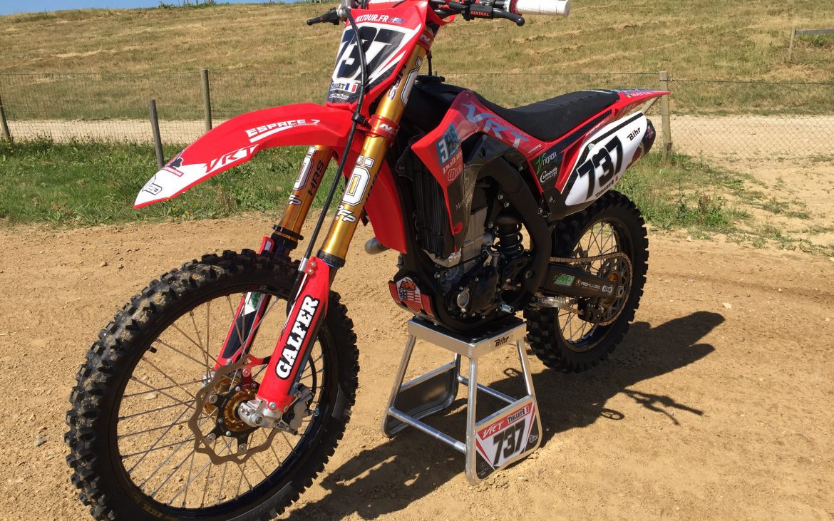 Moto Valentin SX rouge sur un chemin de terre