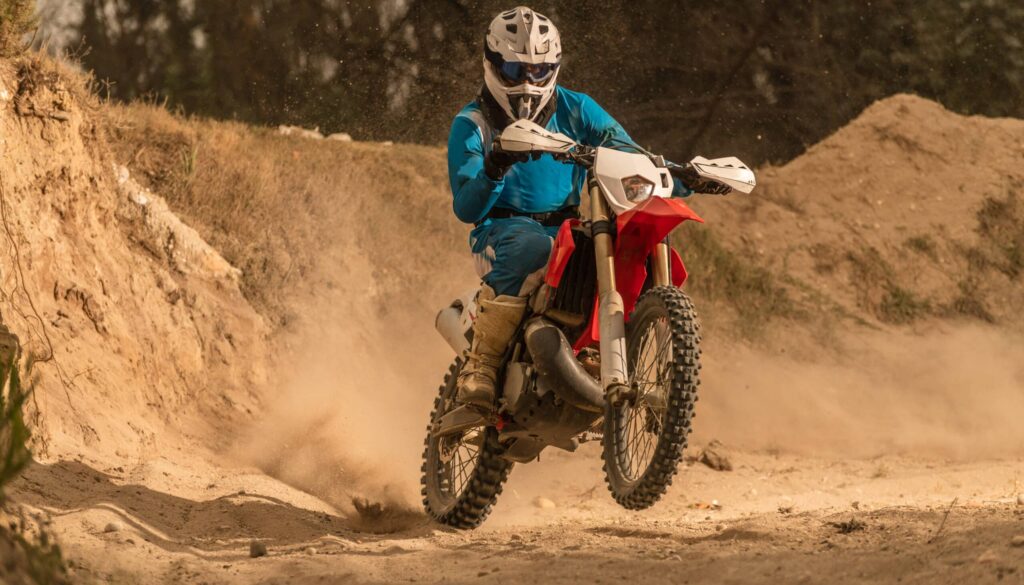 Enduro bike rider on action. Turn on sand terrain.