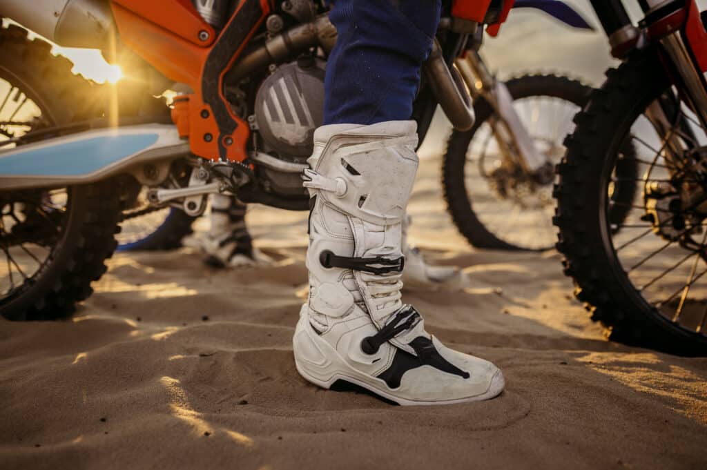 Essais de moto pendant la compétition de motocross bottes de pilote en gros plan