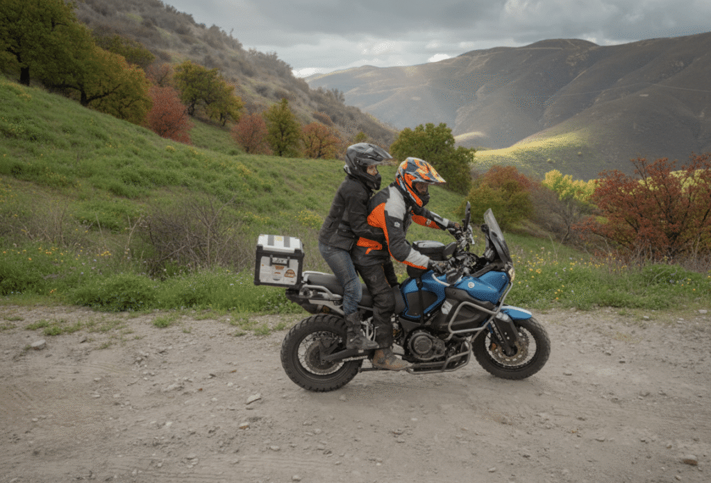 Motorcycle rider and passenger navigating a downhill mountain trail with protective gear and controlled posture