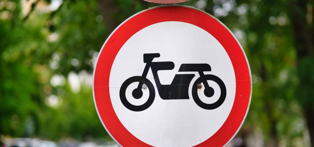Closeup of a road sign indicating that motorcycles are forbidden to proceed.