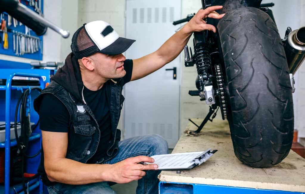 Mechanic checking the wheel of a customized motorcycle in the workshop