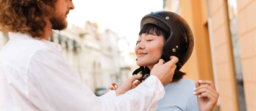 Smiling young man helping his asian girlfriend