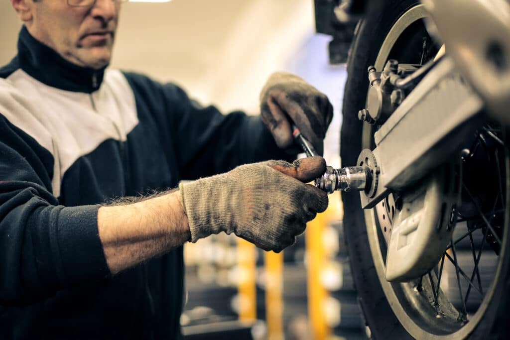 Close-up of a mechanic pouring oil into a compressor engine