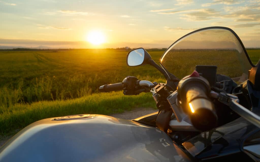 A closeup shot of a motorcycle on a sunset background