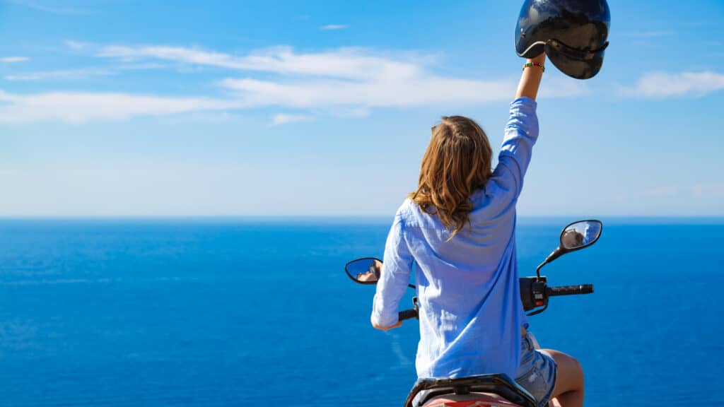 woman-with-scooter-looking-at-the-distand-sea-hori-2026-04-13-02-36-28-utc