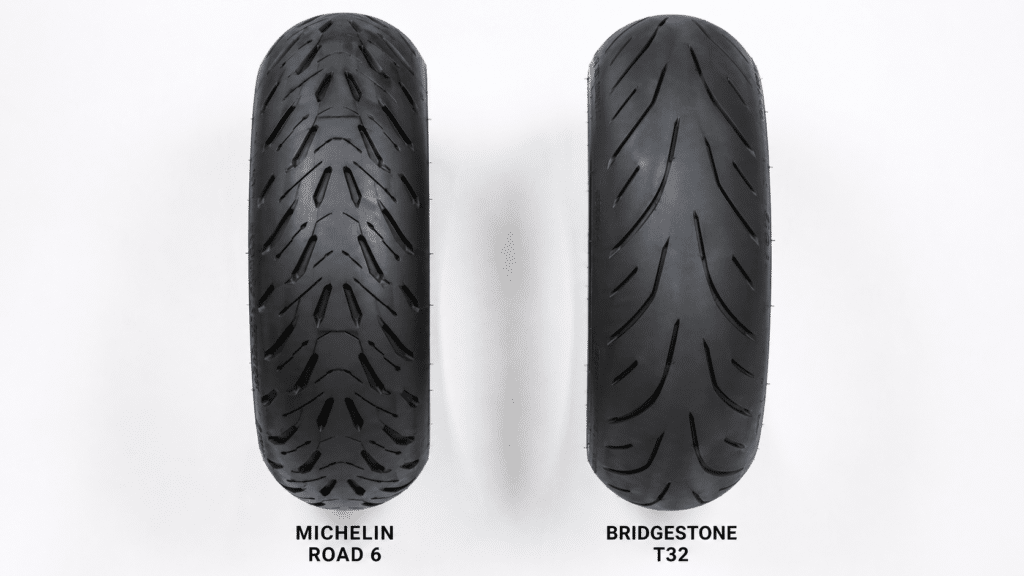 overhead flat lay of Michelin Road 6 and Bridgestone T32 motorcycle tyres on clean white surface