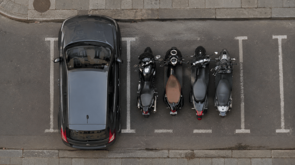 top-down aerial view of an urban street showing how a single car occupies the space of 3 to 5 motorcycles