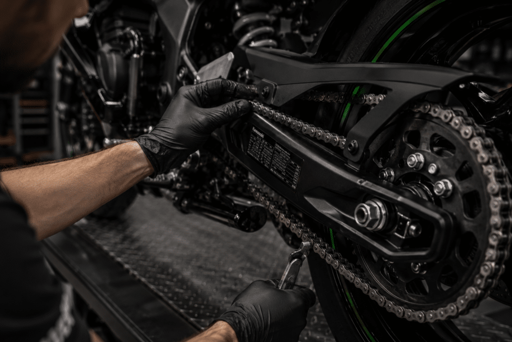 photorealistic mechanic checking chain and sprocket on Kawasaki ZX-4RR motorcycle, workshop lighting, macro detail, no watermark