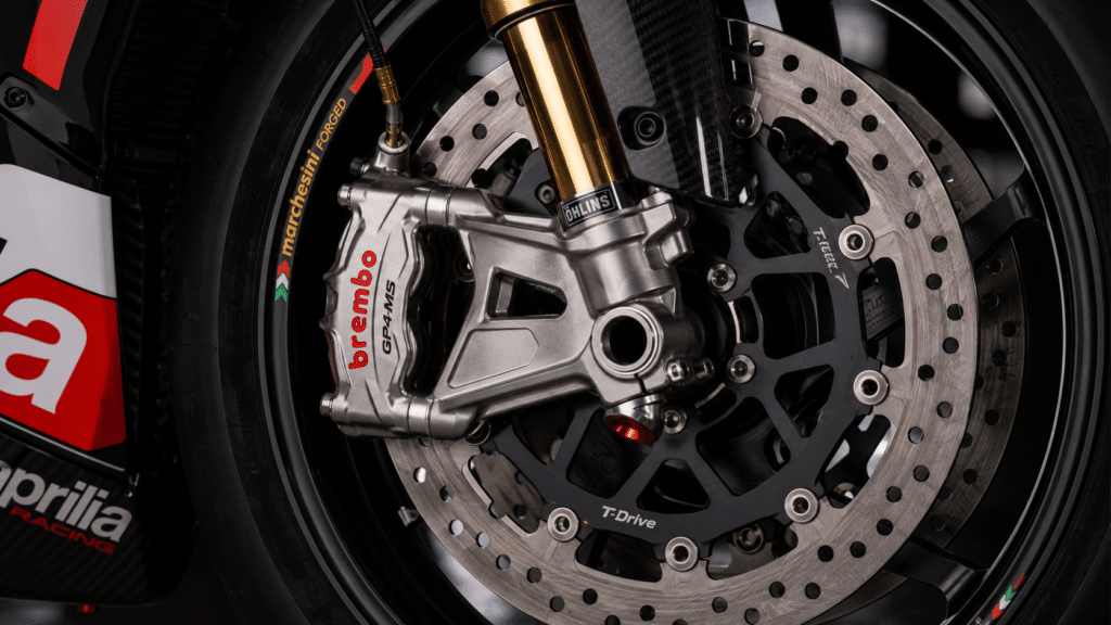 photorealistic, Marchesini forged magnesium wheels with Brembo GP4-MS brake calipers and T-Drive discs on an Aprilia track motorcycle, extreme technical detail photography, dramatic workshop lighting, sense of racing-grade braking system, sharp focus on brake components, no watermark